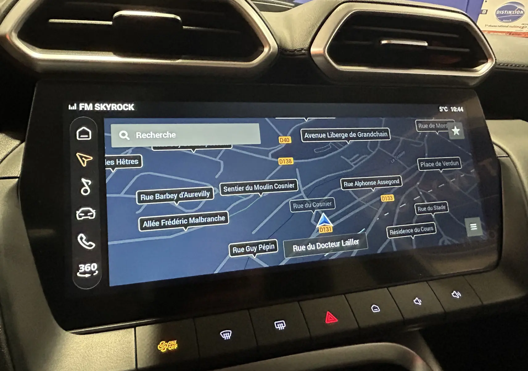 Écran tactile central du MG MOTOR ZS Hybrid+ 197 Luxury 2026, affichant la navigation avec carte et commandes climatisation en dessous.