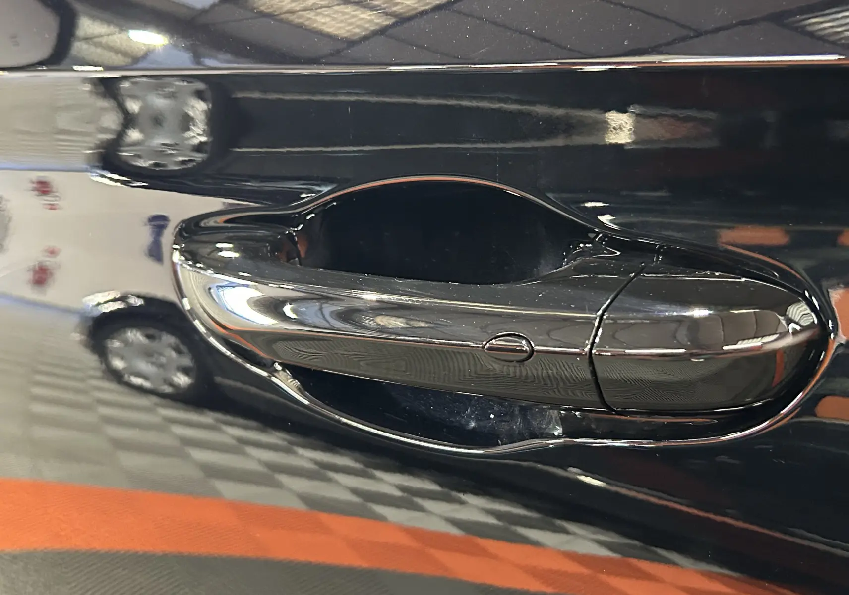 Poignée de porte chromée en gros plan sur la portière Pebble Black d'une MG MOTOR ZS Hybrid+ 197 LUXURY 2026.