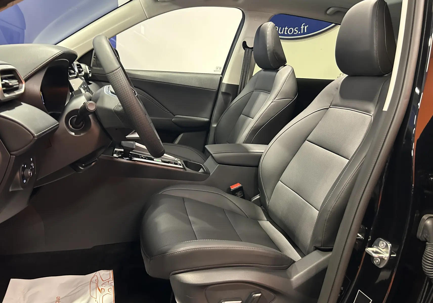 Vue intérieure côté conducteur du MG Motor ZS Hybrid+ 197 Luxury avec sièges cuir noirs et tableau de bord moderne.