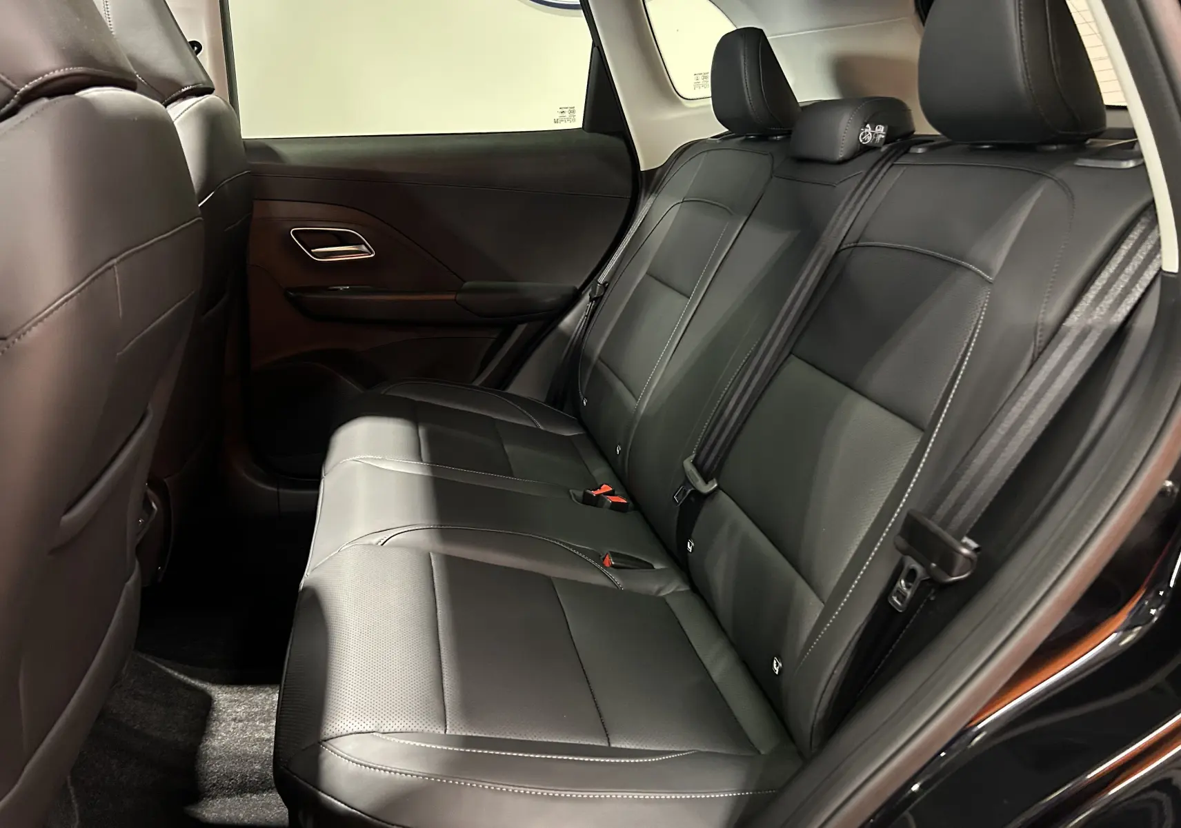 Vue intérieure côté droit des sièges arrière en cuir noir du MG MOTOR ZS Hybrid+ 197 LUXURY 2026 avec ceinture de sécurité visible.