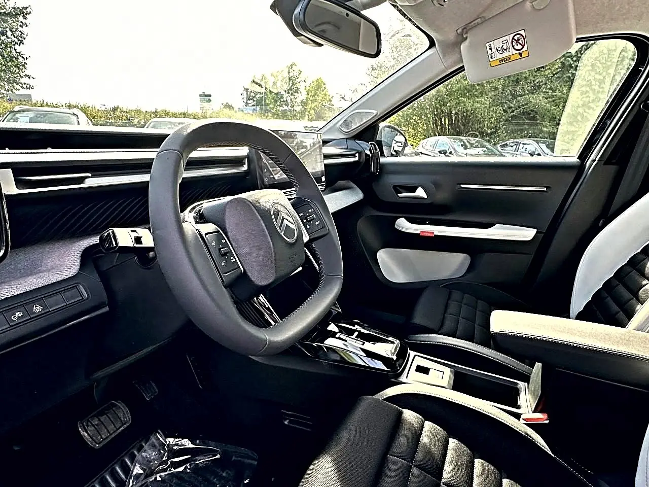 Intérieur avant droit du Citroën C3 Aircross noir 2026, volant multifonction et sièges bi-ton avec accoudoir central.