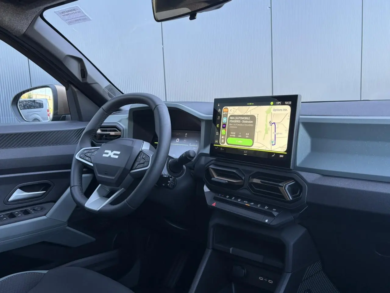 Vue intérieure côté conducteur du Dacia Duster 2026 gris, avec tableau de bord digital et écran tactile central 10 pouces.
