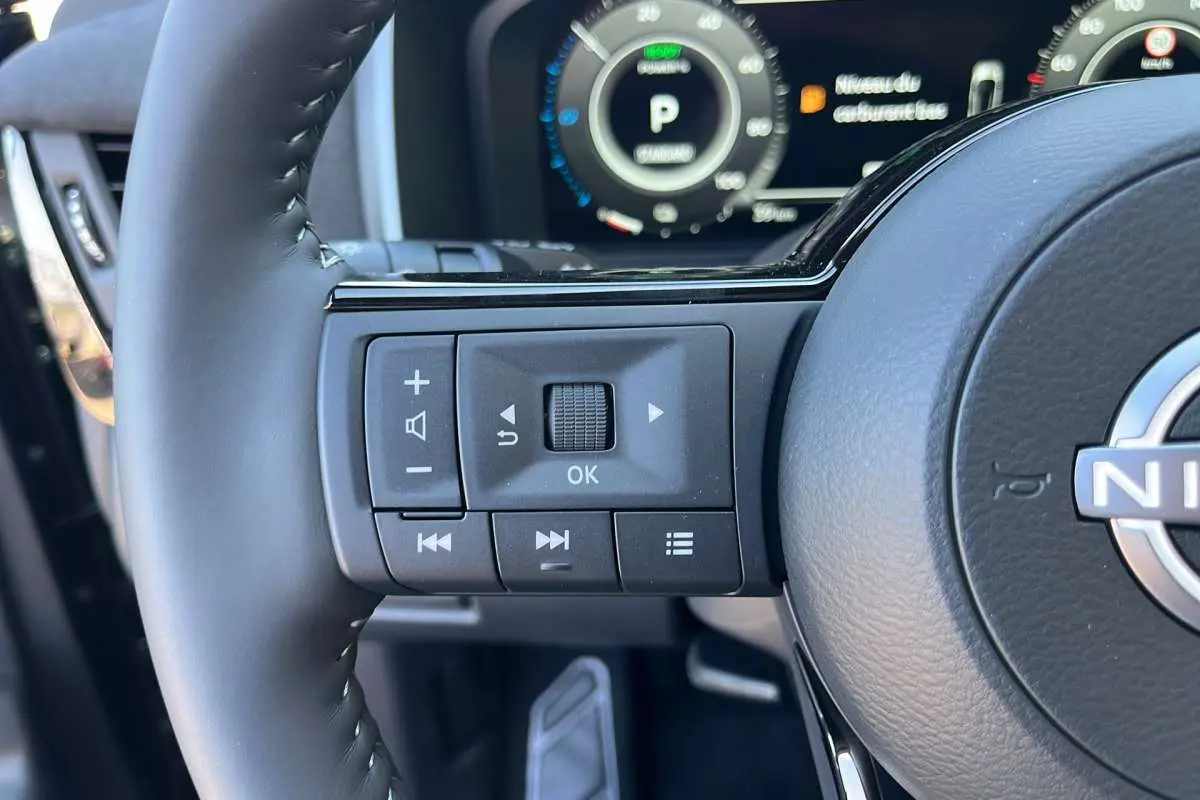 Gros plan sur la partie gauche du volant cuir multifonctions du Nissan Qashqai E-POWER 2026 avec commandes intégrées.