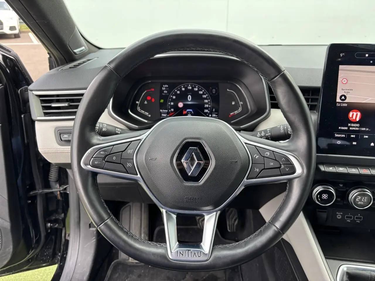 Volant cuir Renault Clio Initiale Paris noir étoilé vu de face, avec tableau de bord numérique et écran tactile central.