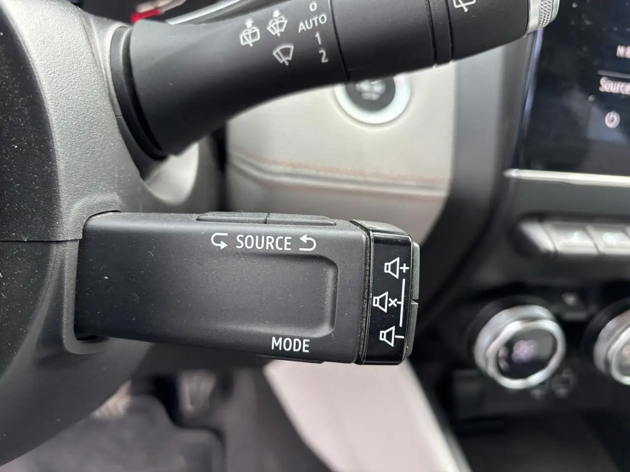 Gros plan sur la commande multimédia au volant noir de la Renault Clio V 1.0 TCE 100 Initiale Paris 2020.