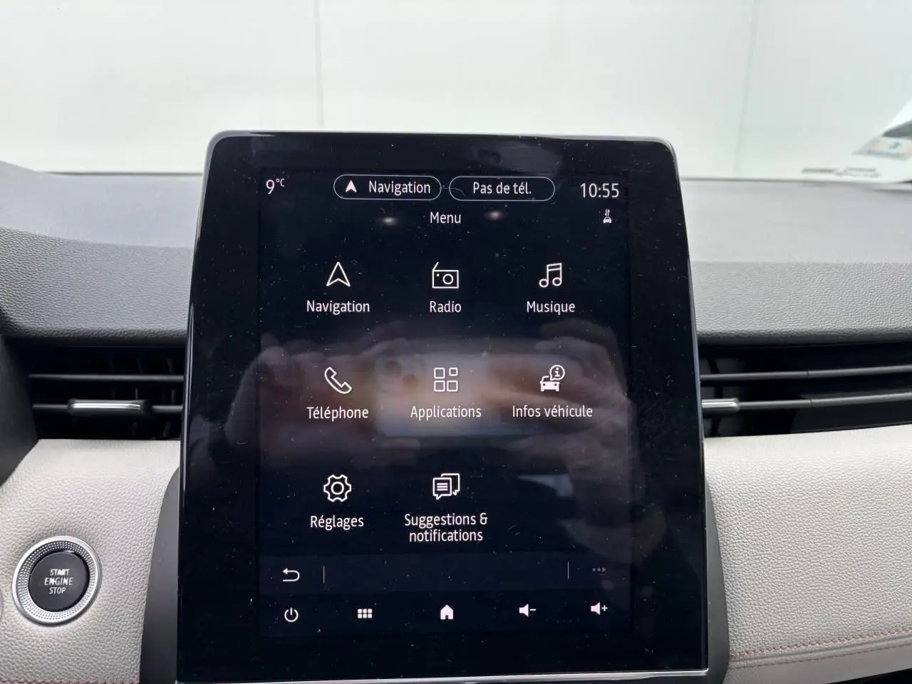 Écran tactile central du tableau de bord de la Renault Clio noire étoile, affichant le menu de navigation et applications.