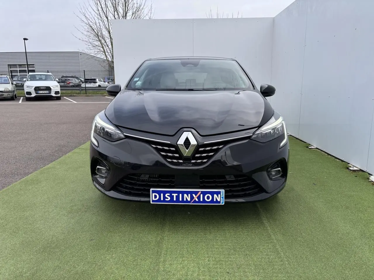 Vue frontale d'une Renault Clio noire étoile avec calandre chromée et phares LED Pure Vision allumés.