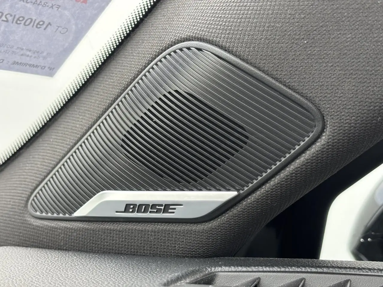 Gros plan sur l'enceinte Bose intégrée côté gauche de l'habitacle d'une Renault Clio noire étoile 2020.