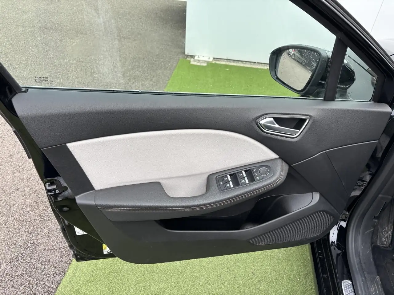 Vue côté gauche de la porte avant noire étoile de la Renault Clio 2020 avec commandes électriques et accoudoir bicolore.