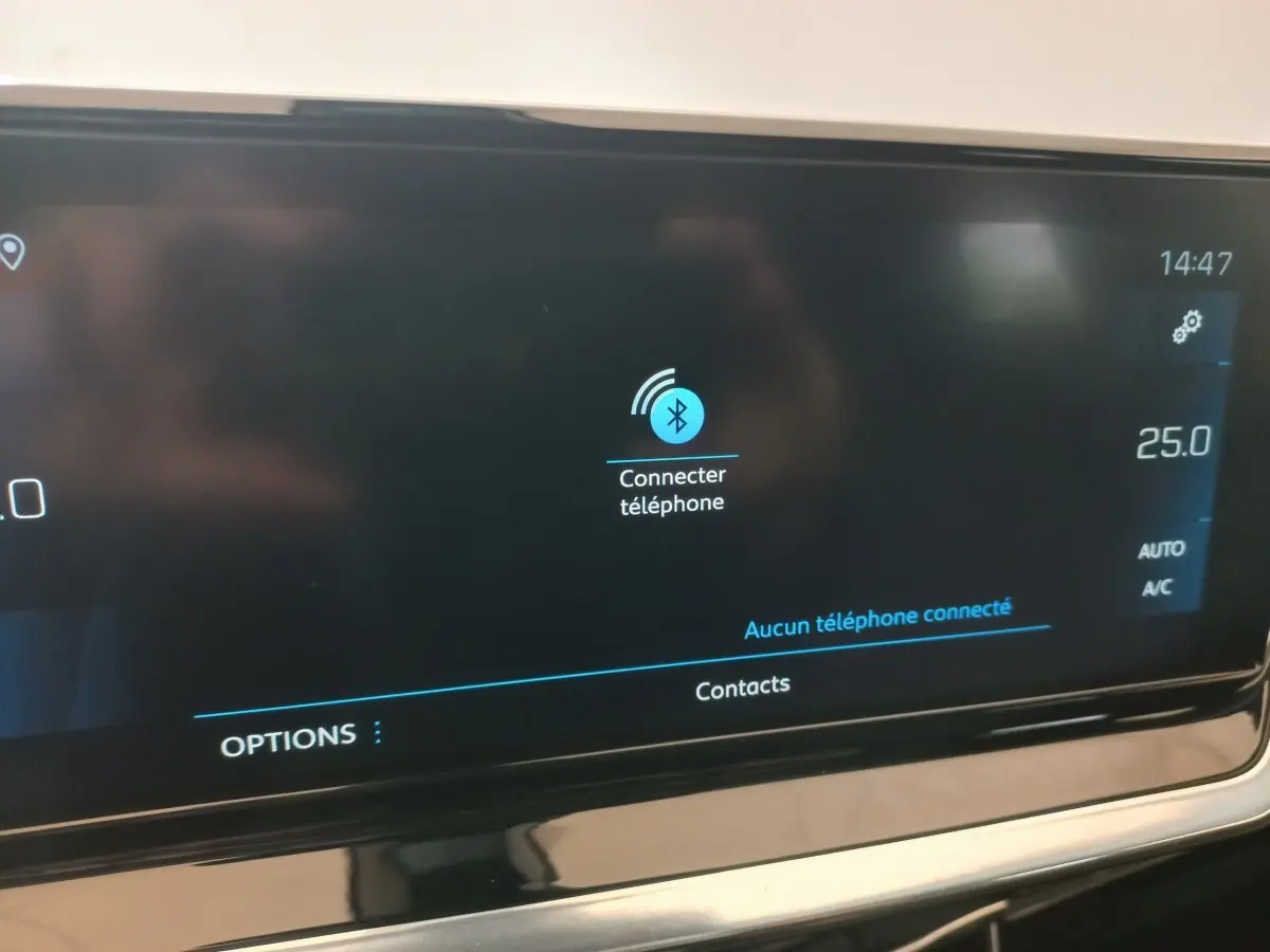 Écran tactile central de 10 pouces du tableau de bord du Peugeot 2008 Orange, affichant la connexion Bluetooth téléphone.