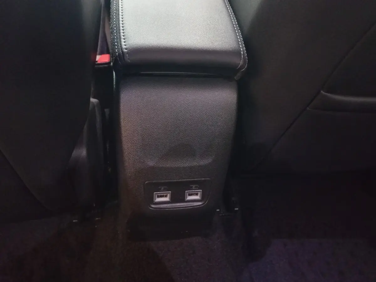 Prise USB double vue arrière entre les sièges noirs du Peugeot 2008 BlueHDi 110 S&S Allure Business 2021.
