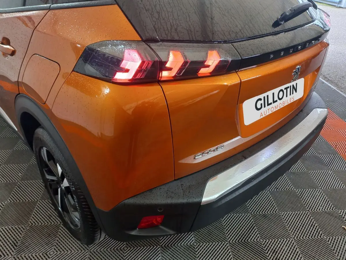 Vue 3/4 arrière droite du Peugeot 2008 orange avec feux arrière LED et logo visible sur le hayon