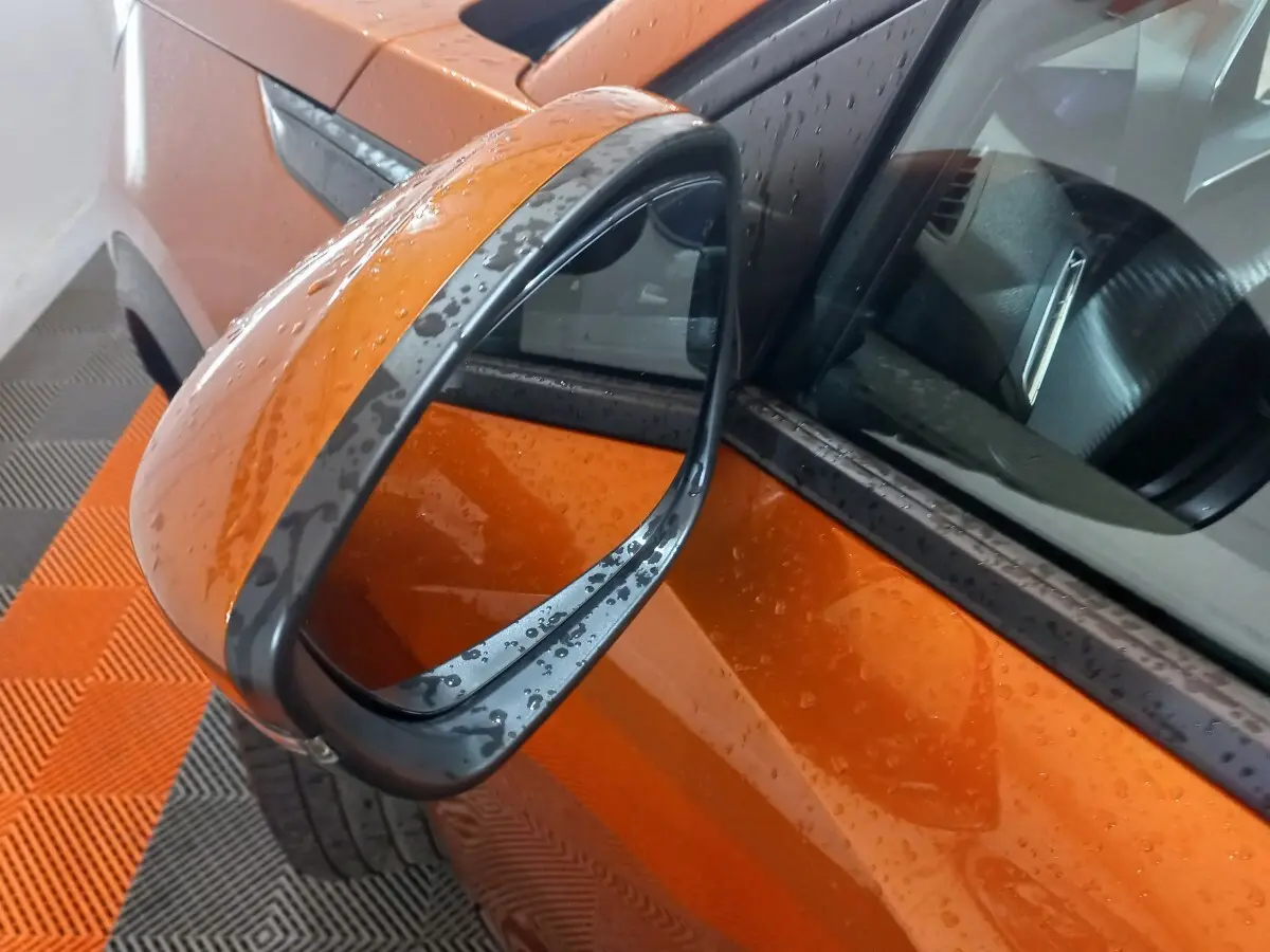 Rétroviseur côté gauche orange de Peugeot 2008 BlueHDi 110 2021 avec gouttes d'eau sur carrosserie et miroir.