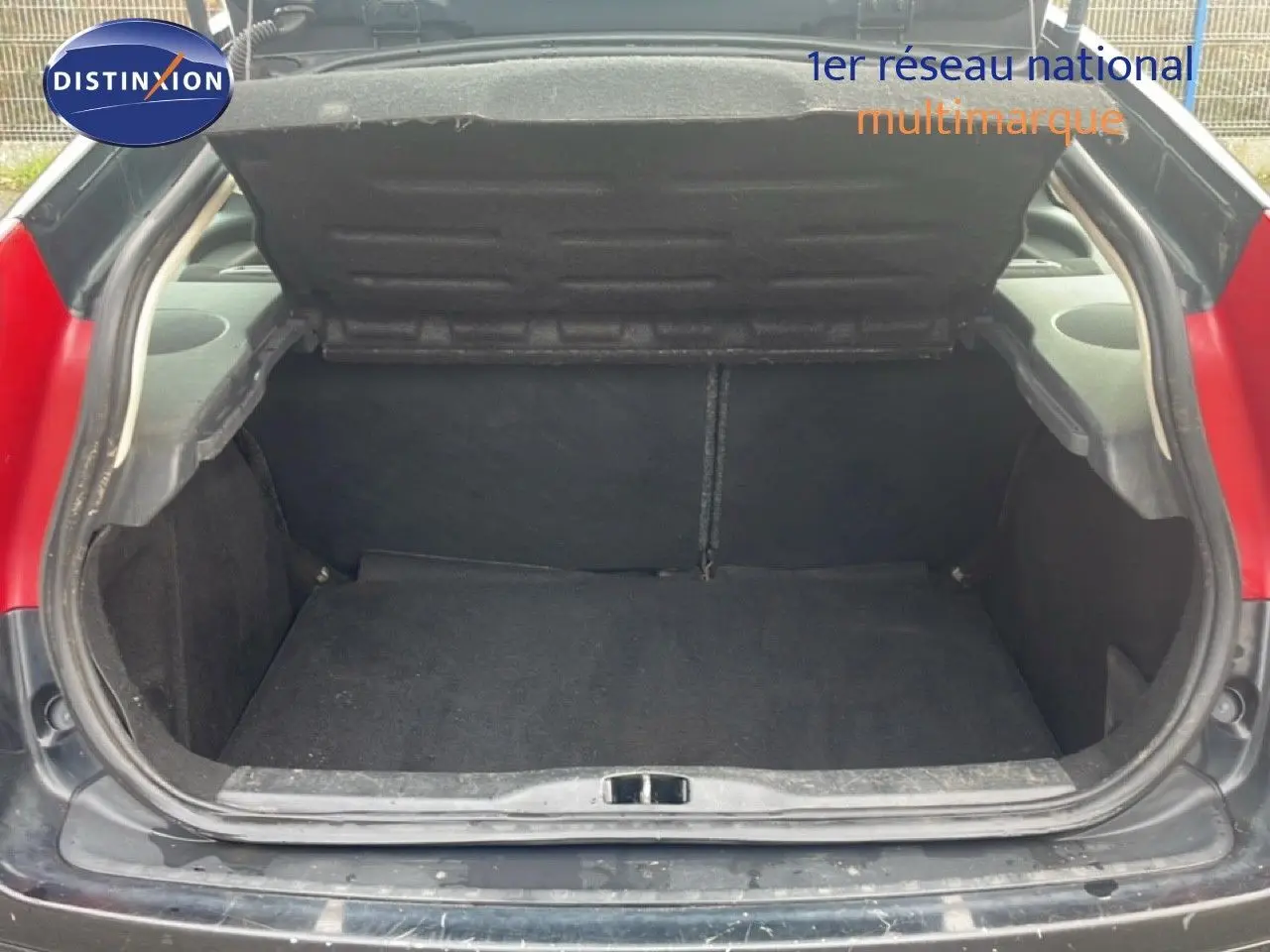 Coffre ouvert d'une Citroën C4 Coupé noir métal 3 portes, vue arrière centrée montrant l'espace de chargement vide.