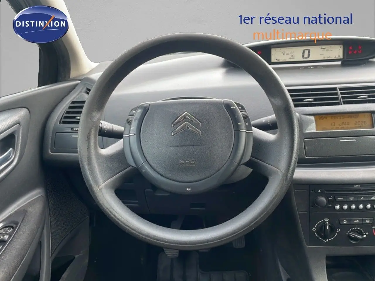 Vue intérieure centrée sur le volant et tableau de bord d'une Citroën C4 Coupé 2009, ambiance sobre et fonctionnelle.