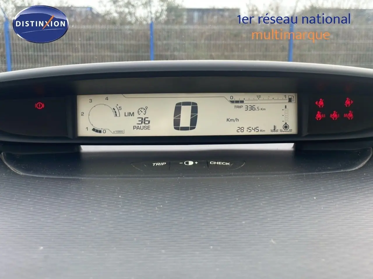 Tableau de bord numérique de Citroën C4 noir métal 2009, affichage central avec compteur et voyants rouges allumés.