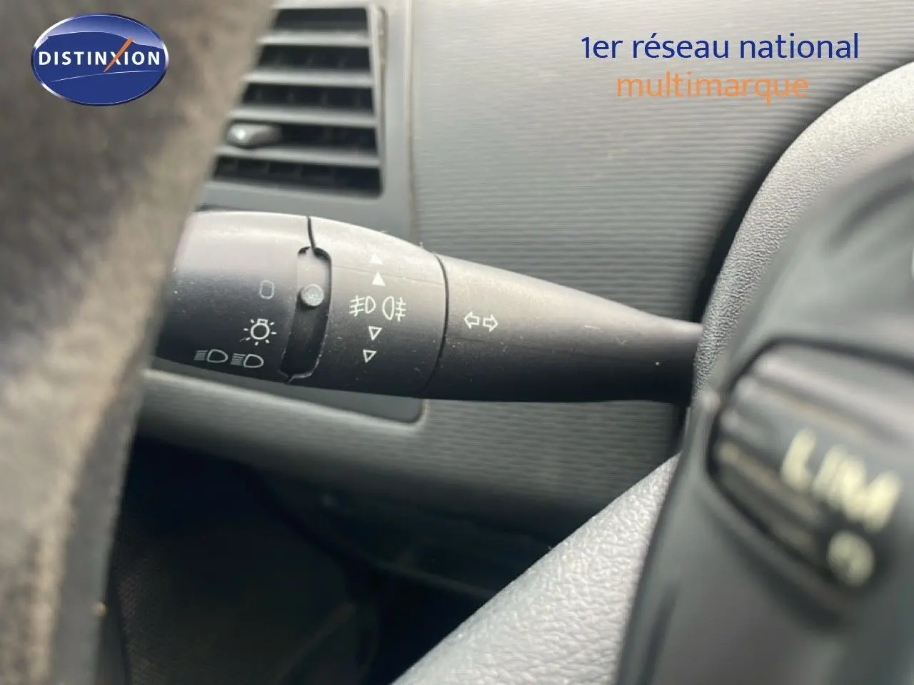 Gros plan sur la manette de clignotants à gauche du volant dans l’habitacle d’une Citroën C4 Coupe noir métal de 2009.