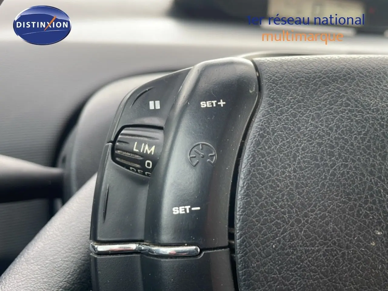 Gros plan sur les commandes de régulateur de vitesse au volant d’une Citroën C4 Coupé noir métal de 2009.
