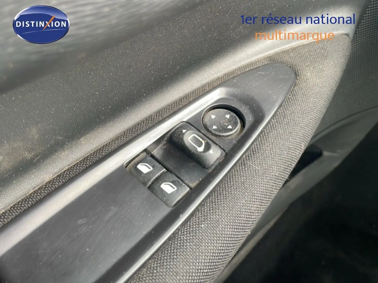 Détail des commandes électriques sur la porte côté gauche d’une Citroën C4 Coupé noir métal de 2009.