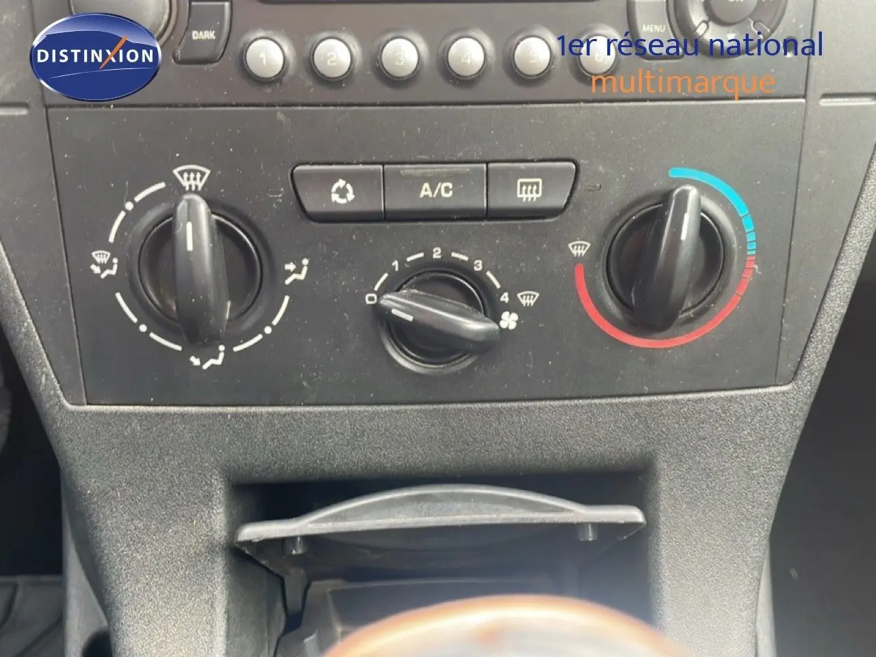Vue rapprochée du tableau de bord et des commandes de climatisation d'une Citroën C4 Coupe noire de 2009.