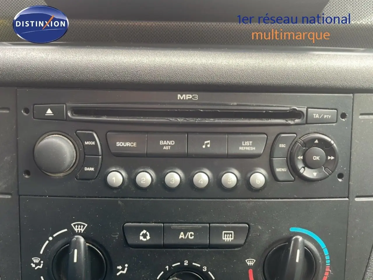 Vue rapprochée du tableau de bord de la Citroën C4 2009, montrant la radio MP3 et les commandes de climatisation.