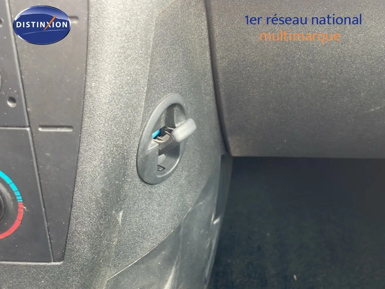 Détail intérieur montrant la commande d'ouverture de la boîte à gants sur une Citroën C4 Coupé noir métal de 2009.