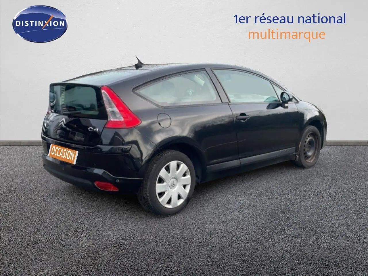 Vue 3/4 arrière droite d'une Citroën C4 Coupé noire métal de 2009 avec jantes acier et feux arrière distinctifs.