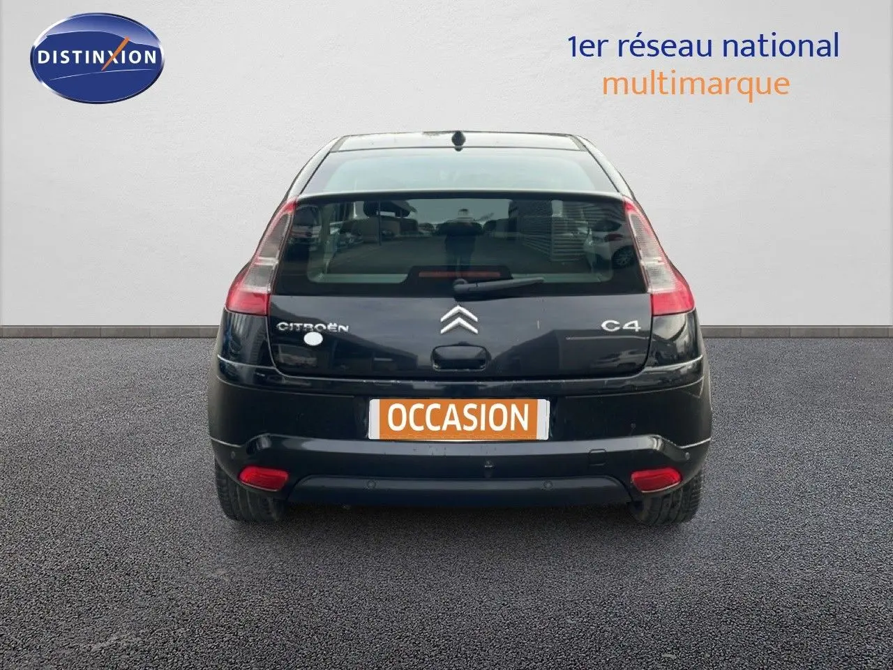 Vue arrière d'une Citroën C4 Coupé 2009 noir métal, avec feux arrière allongés et plaque "Occasion" visible.