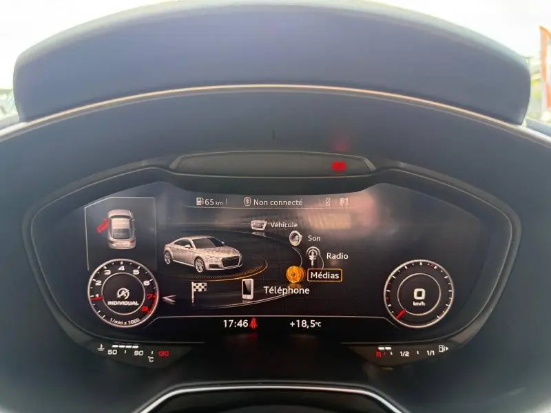 Vue rapprochée du tableau de bord numérique de l'Audi TT Coupé 2016, affichant les menus médias et véhicule.