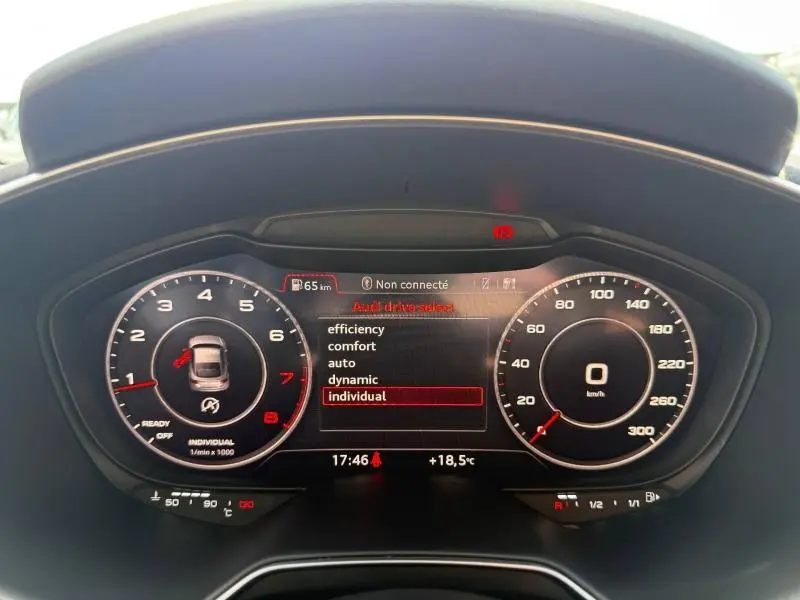 Vue rapprochée du tableau de bord numérique noir de l'Audi TT Coupé 2016 avec affichage des modes de conduite.