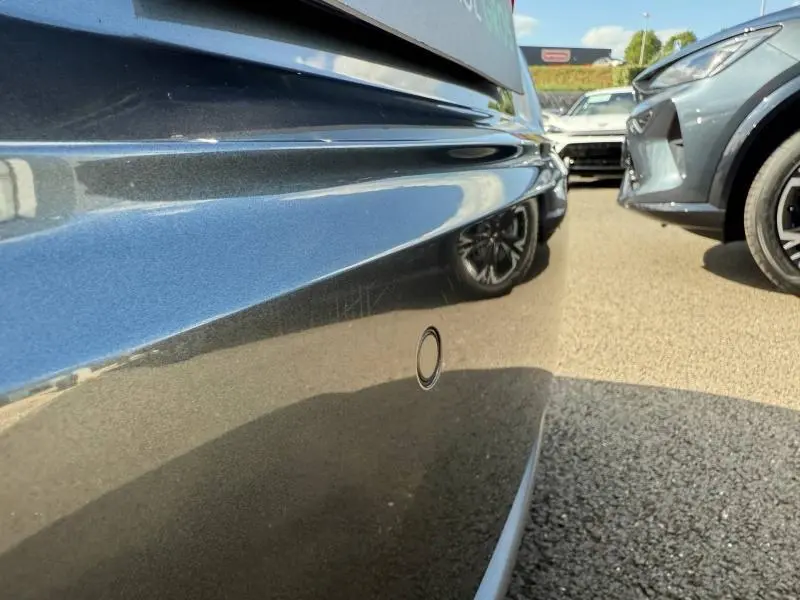 Gros plan sur le pare-chocs arrière gris métallisé de l'Audi TT Coupé 2016 avec capteur de stationnement visible.