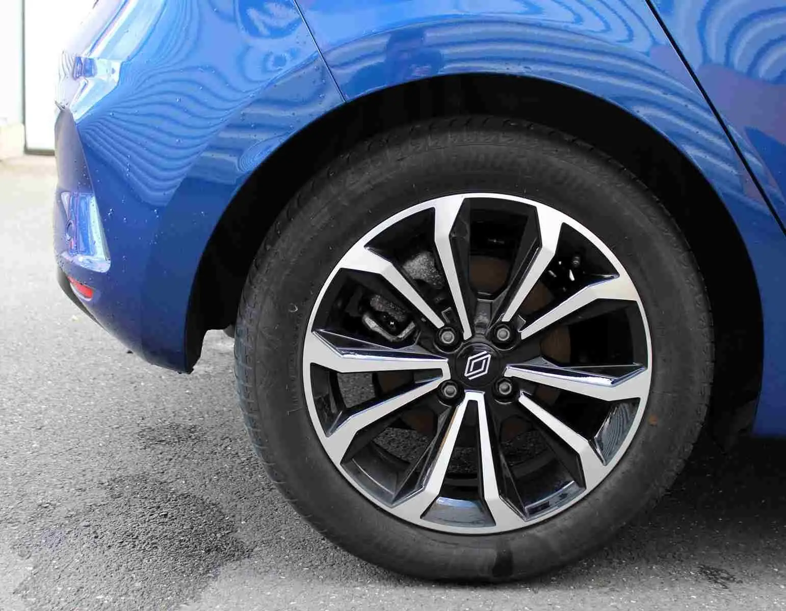 Gros plan sur la roue avant gauche de la Renault Clio bleu iron metal, mettant en valeur la jante alliage au design moderne.