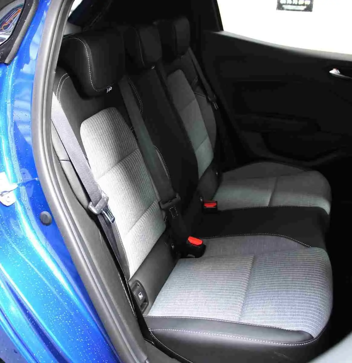Vue intérieure côté gauche des sièges arrière gris clair et noir d'une Renault Clio bleu iron metal 2025.