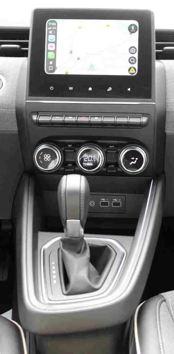 Vue rapprochée de la console centrale de la Renault Clio hybride 2025, avec écran tactile et levier de boîte automatique.