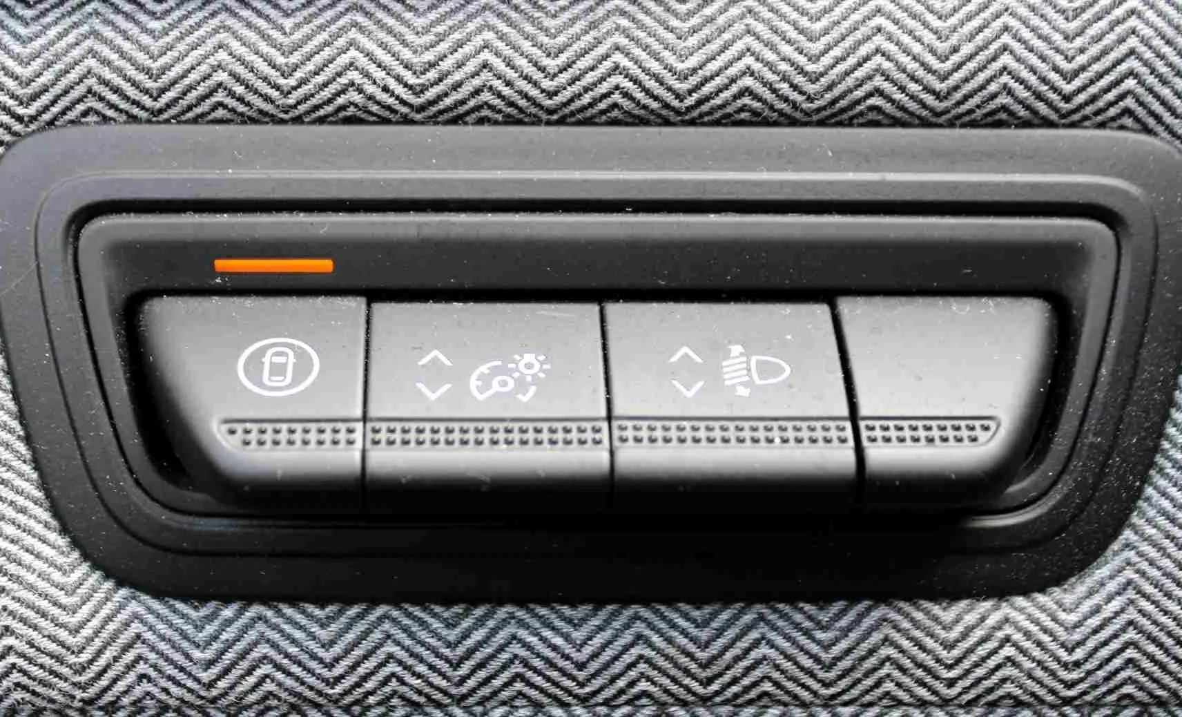Gros plan sur les boutons de réglage d’éclairage et verrouillage dans l’habitacle de la Renault Clio hybride bleu iron metal.