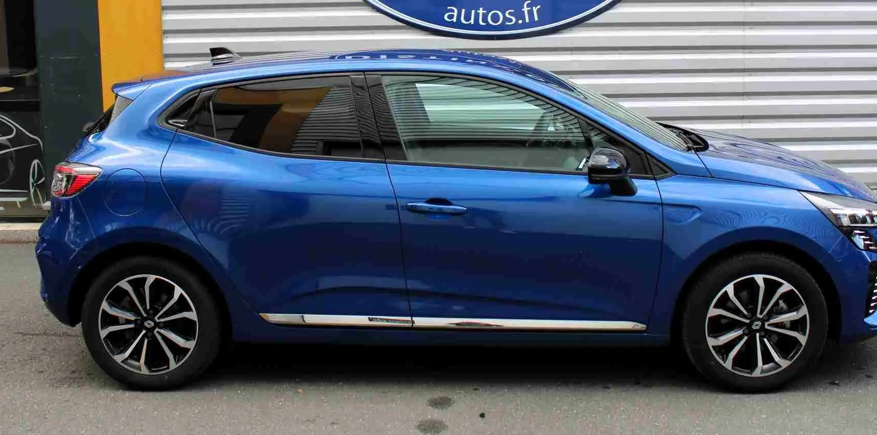 Profil droit de la Renault Clio 2025 bleu Iron Metal avec jantes alliage et détails chromés sur bas de caisse.