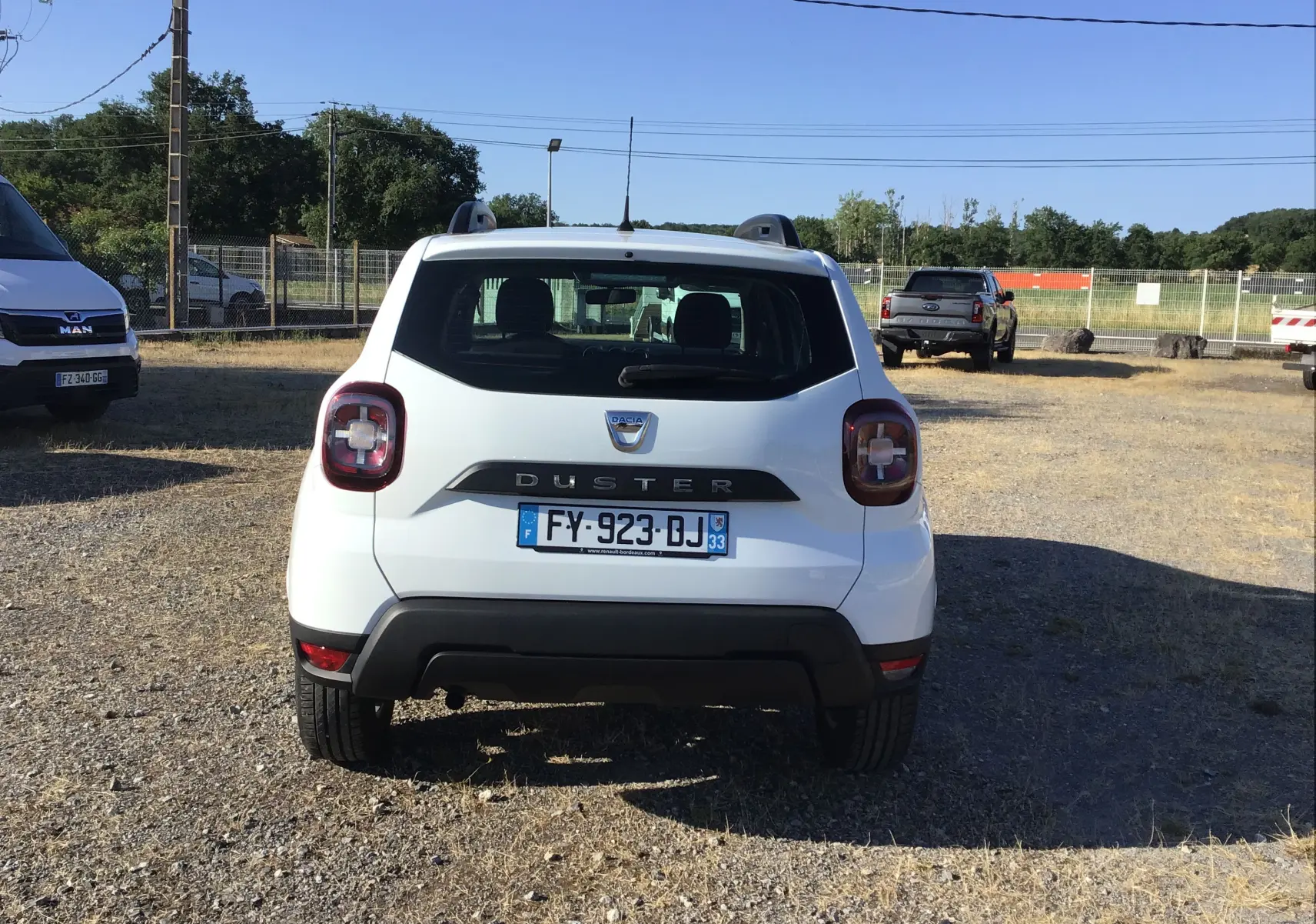 Vue arrière d'un Dacia Duster blanc 2021, version 4x2 Eco-G, avec logo et plaque d'immatriculation visibles.