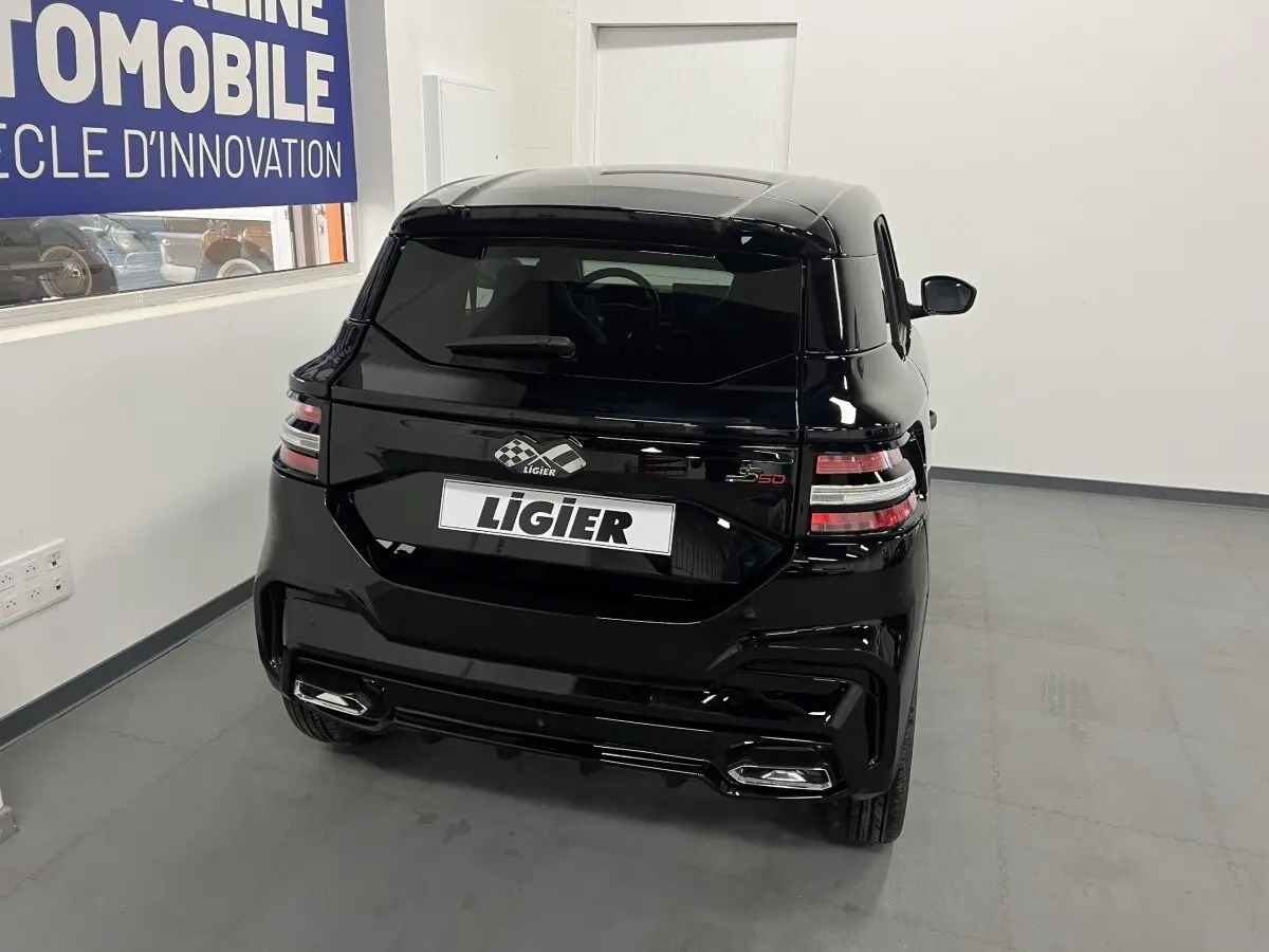 Vue arrière d'une Ligier JS50 0.5 REVO D+ Ultimate noire brillante, avec feux LED et double sortie d'échappement intégrée.