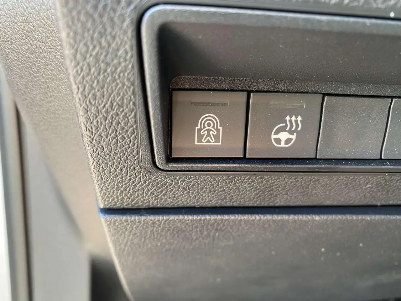 Boutons de commande du tableau de bord du Citroën Berlingo 2025, vue rapprochée sur les fonctions de sécurité et de chauffage du volant.