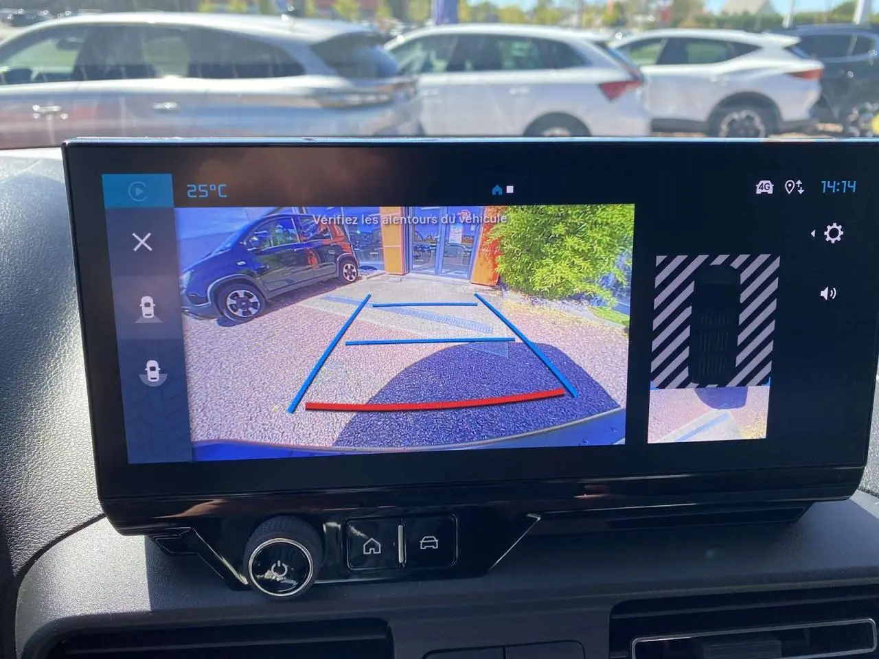 Écran tactile intérieur montrant la caméra de recul du Citroën Berlingo blanc avec guidage de stationnement.