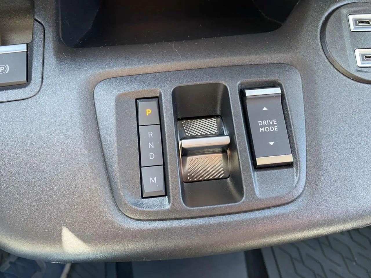 Gros plan sur la console centrale noire du Citroën Berlingo 2025, avec commandes de boîte auto et mode de conduite.