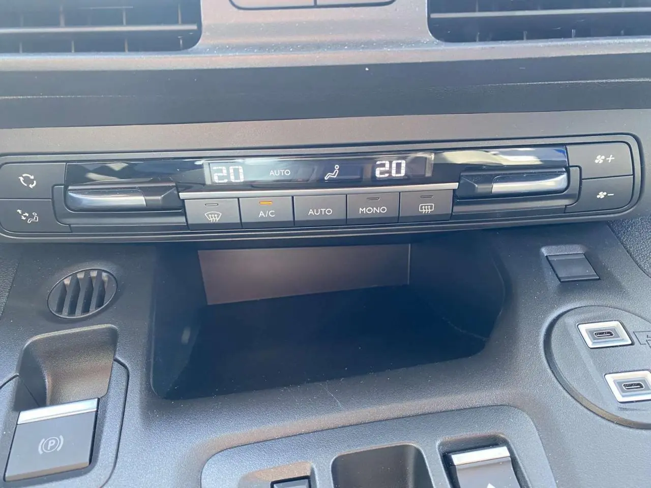 Détail de la console centrale du Citroën Berlingo 2025, montrant la climatisation automatique et le frein de stationnement électrique.