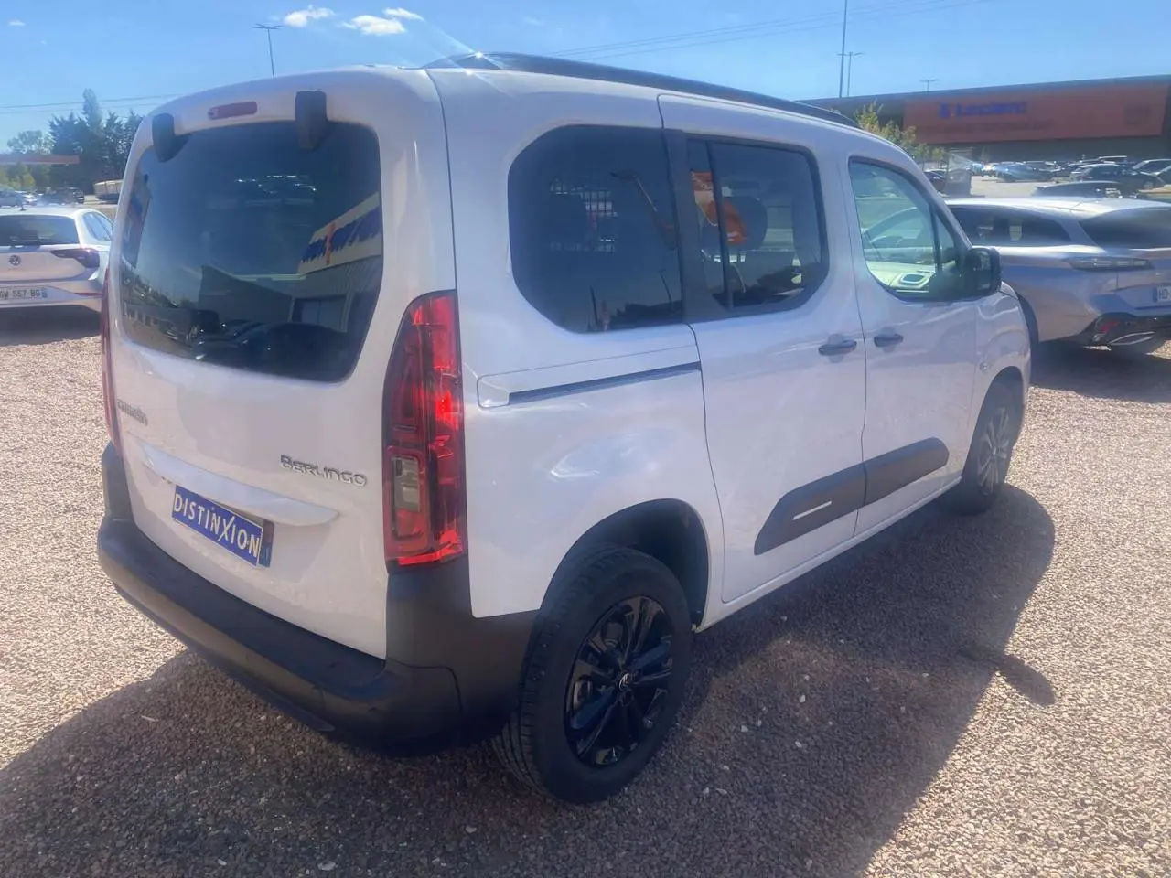 Vue 3/4 arrière droite d'un Citroën Berlingo blanc 2025 avec portes coulissantes et hayon vitré dégivrant.