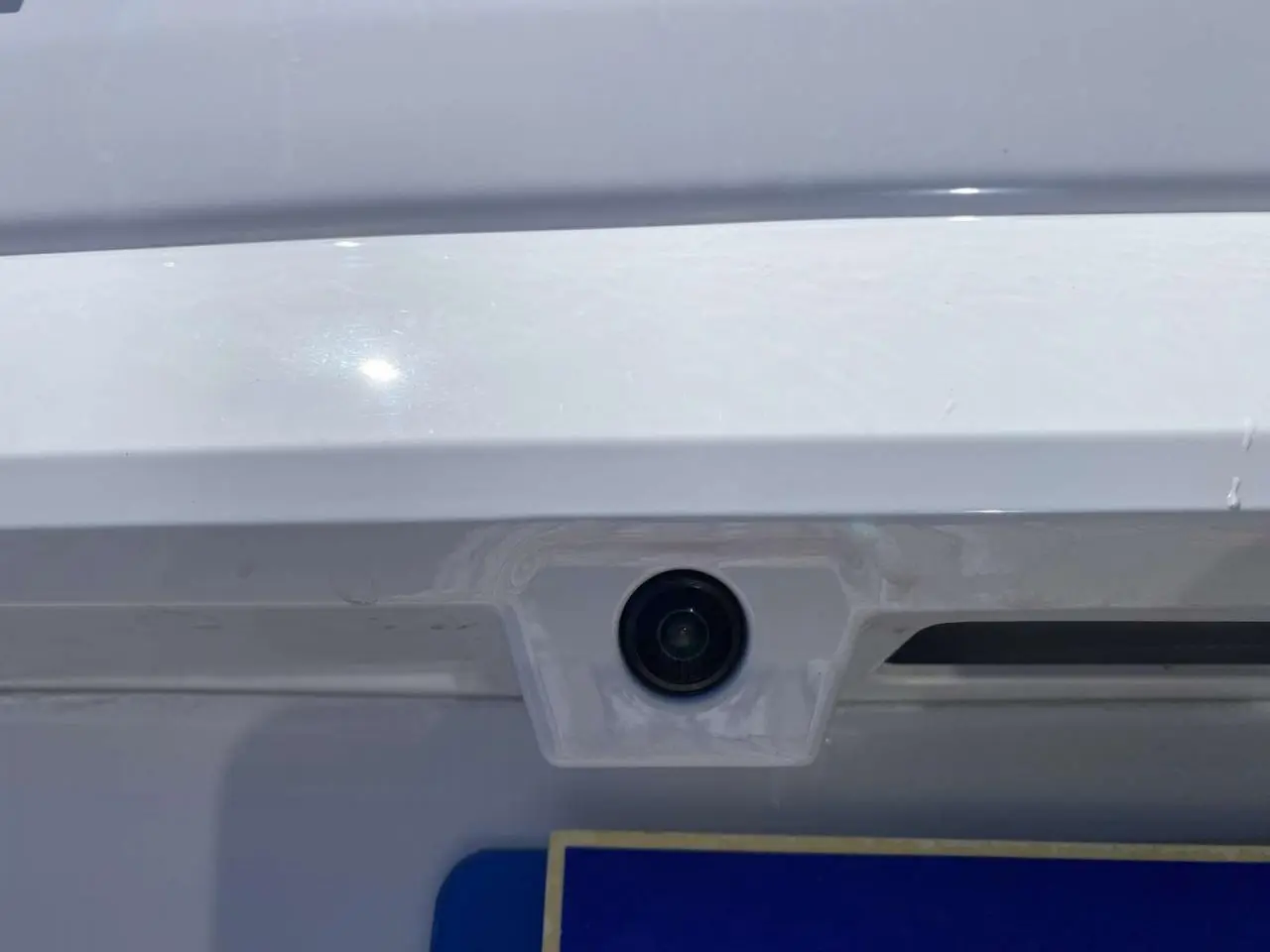 Gros plan sur la caméra de recul intégrée au hayon blanc du Citroën Berlingo 2025, version diesel automatique.