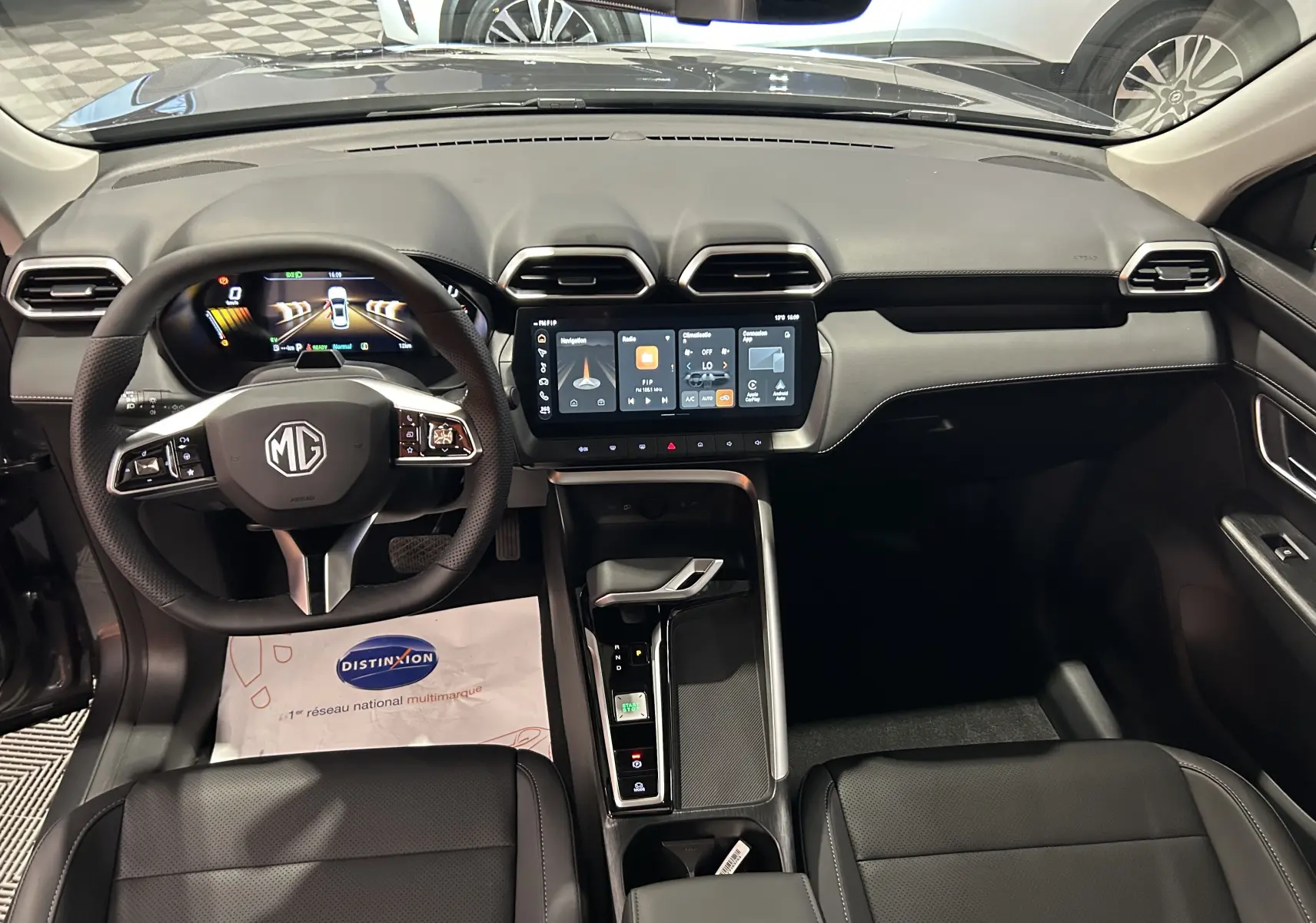 Vue intérieure avant du MG ZS Hybrid+ 197 Luxury avec tableau de bord numérique et écran tactile central, finition noire élégante.