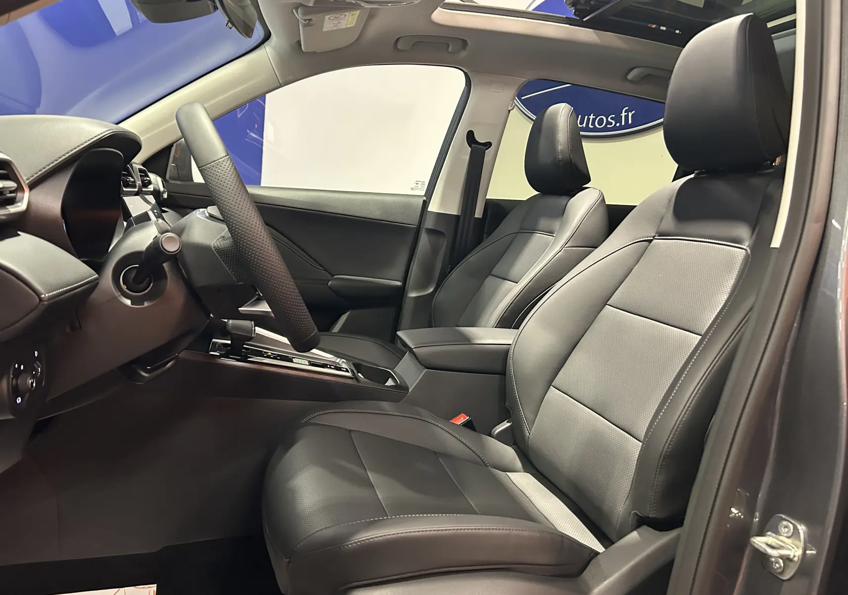 Vue intérieure côté conducteur du MG ZS Hybrid+ 197 Luxury 2026, sièges cuir noirs et toit panoramique ouvrant.
