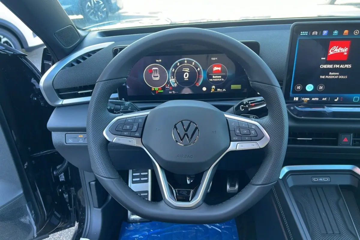 Vue intérieure centrée sur le volant cuir multifonctions du Volkswagen T-Roc 2026 avec tableau de bord digital et écran tactile.