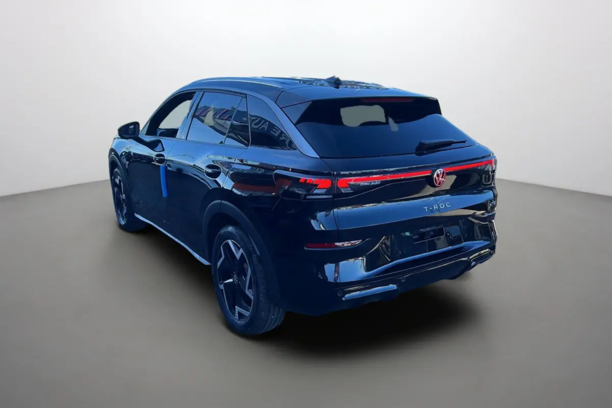 Vue 3/4 arrière droite du Volkswagen T-Roc noir ebène avec feux arrière LED et jantes alu 18 pouces noires.