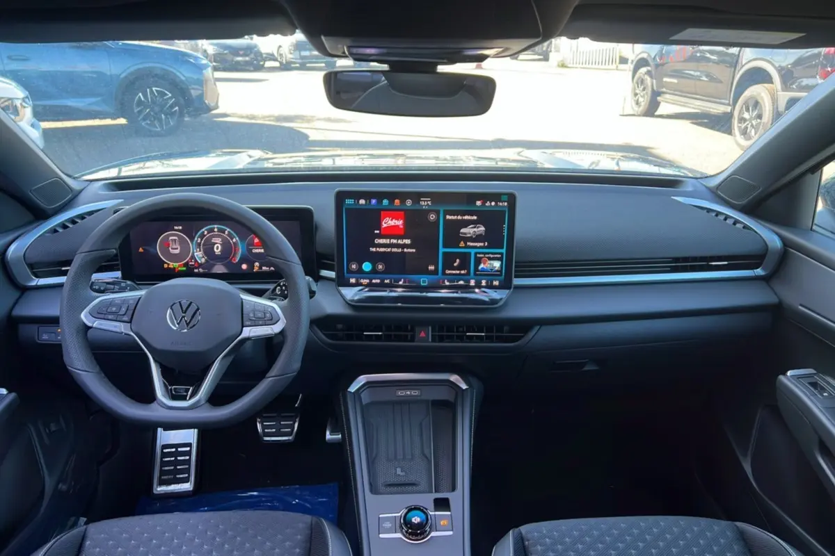 Intérieur noir du Volkswagen T-Roc 2026 vu de face, avec tableau de bord digital et écran tactile central.