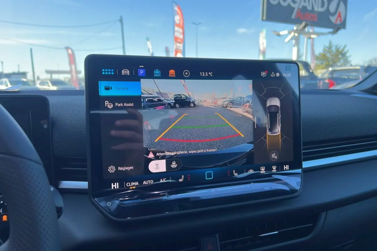 Écran central tactile du Volkswagen T-Roc noir ebène 2026 montrant la caméra de recul et l'assistance au stationnement.
